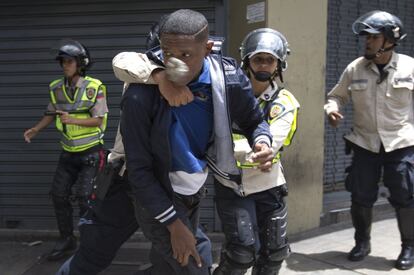 Un agente de policía detiene a un manifestante.