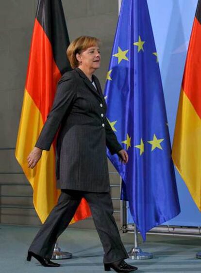 Angela Merkel se dirige a la rueda de prensa, ayer, en Berlín.