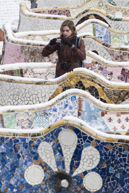 Una chica fotografía la nieve en el Parque Güell.