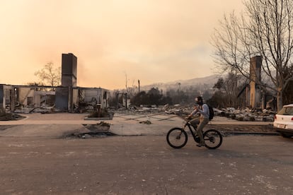 Un ciclista pasa por Pacific Palisades, en una de las zonas arrasadas por el fuego de los incendios de Los Ángeles, California, el 9 de enero de 2025.