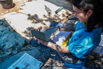 Lara de la Cita, bióloga de la excavación, documenta una de las muestras de manera tradicional, con un bolígrafo y un papel.  En las fichas se registra el tipo de fósil encontrado, su tamaño, las características de su preservación y una sigla que permitirá clasificar y facilitar la búsqueda de los ejemplares una vez se incorporan a la colección.