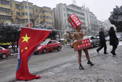 Un hombre anuncio semidesnudo trabaja en una calle nevada de Zhumadian, China.