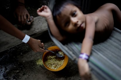 Un niño yanomami es alimentado con arroz y farofa (mandioca rayada) mientras es tratado en el centro de salud de la base aérea de Auaris. El año pasado, de acuerdo al Gobierno, 308 yanomami murieron de enfermedad, malnutrición y violencia el año pasado. El 50% de las muertes fueron de infantes menores de 4 años.