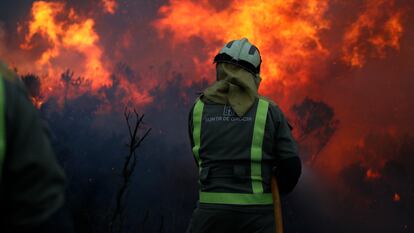 Un bombero participa en las labores de extinción del incendio forestal en Baleira (Lugo), este miércoles.
