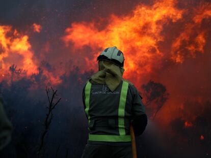 Un bombero participa en las labores de extinción del incendio forestal en Baleira (Lugo), este miércoles.