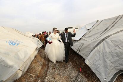 Jassim Mohammed y Amena Ali, durante la ceremonia de celebración de su boda, en un campamento de refugiados en Khazir, cerca de Mosul, Irak. Ambos caminan entre las tiendas de campaña donde viven.