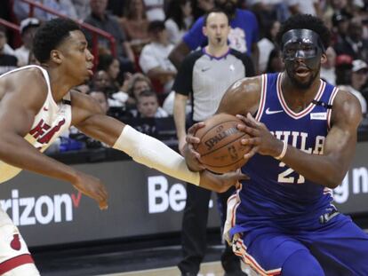 Whiteside trata de frenar a Embiid, con la máscara.