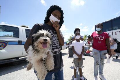 Tiara Walker sostiene a su perro, Buece, mientras espera con su familia para abordar un autobús y salir de Galveston, Texas.