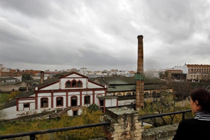 Una mujer observa el complejo industrial de la antigua fábrica de vidrio La Trinidad de Sevilla.