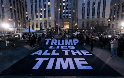 Varias personas despliegan una pancarta contra Trump frente al Tribunal Penal de Nueva York, el jueves.
