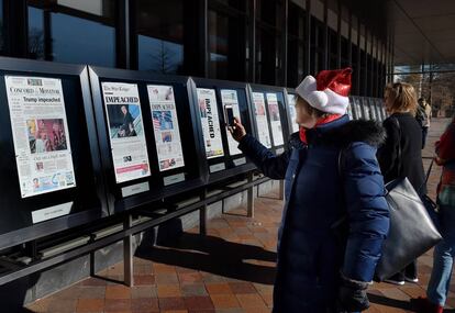 Visitantes fotografiando en el Newseum, el pasado jueves, portadas de periódicos sobre el 'impeachment' a Trump.