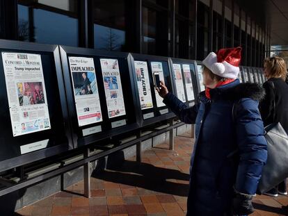 Visitantes fotografiando en el Newseum, el pasado jueves, portadas de periódicos sobre el 'impeachment' a Trump.