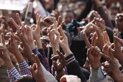 Manifestantes contrarios al régimen hacen el signo de la victoria en la plaza de la Liberación.