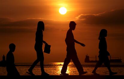 Cientos de filipinos acuden cada año a la bahía de Manila para contemplar la última puesta de sol del año.