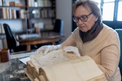 Liliane Dahlmann hojea un volumen del archivo.