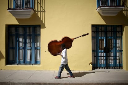 El músico Frilal Ortiz transporta su chelo en La Habana, Cuba.