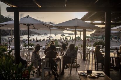 Varias personas en la terraza del bar Roca y Mar, en la cala Benirrás de Ibiza.