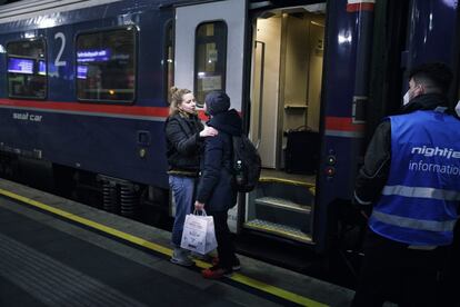 Despedida en un andén de la Estación Central de Viena. La pareja está junto a un vagón con reservas de asiento para viajar de noche.