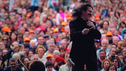 Luis Cobos, melena al viento, dirigiendo la orquesta de RTVE en la Plaza de Oriente de Madrid.