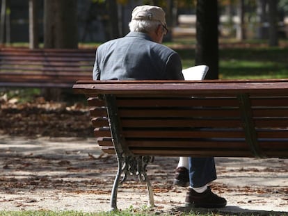 Un jubilado lee el periódico en un parque de Madrid.