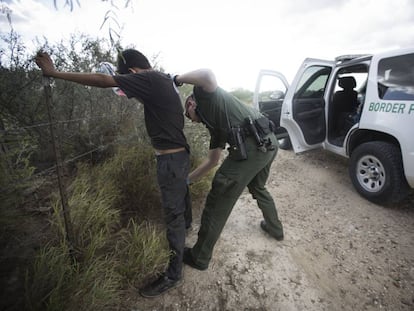 A border control agent searches an undocumented immigrant in Roma, Texas.