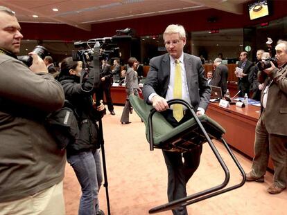 El ministro sueco de Exteriores, Carl Bildt, coloca una silla antes de iniciarse la reunión con sus homólogos europeos ayer en Bruselas.