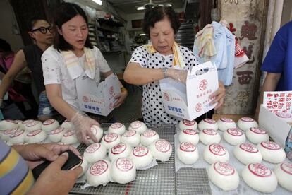Dependientas venden los bollos típicos chinos con el símbolo chino 'paz'. 