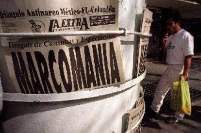 Un vecino de Ciudad de México echa un vistazo a los titulares del día entre los que destaca el del diario <i>La Extra.</i>