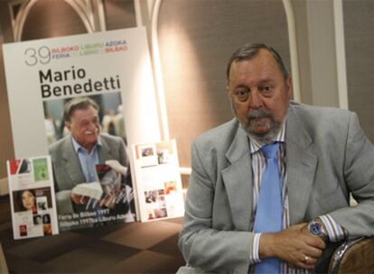 Lorenzo Portillo posa junto a un cartel de la Feria del Libro, que este año recuerda la visita a Bilbao en 1997 del recientemente fallecido poeta Mario Benedetti.