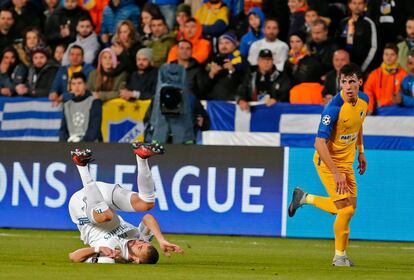 El delantero Karim Benzema cae al suelo al lado del defensa del APOEL Praxitelis Vouros.
