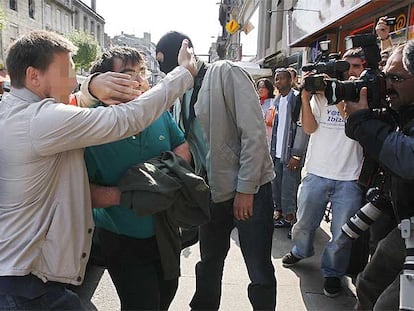 Francisco Javier López Peña, con las manos tapadas, es conducido por policías para asistir al registro del piso de Burdeos donde fue arrestado.