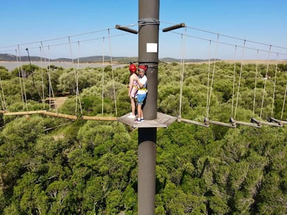 Dos niños disfrutan de las tirolinas en la finca Wakana Lake Camp, un 'glamping' en pleno parque natural de los Alcornocales en Cádiz.