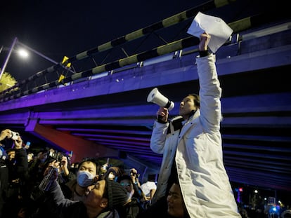 Un hombre sostiene hojas de papel en blanco en protesta por las restricciones en Pekín, el pasado 28 de noviembre.