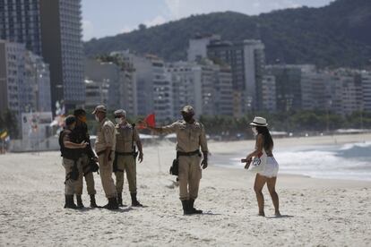 Agentes de policía vigilan la entrada de la playa del Arpoador, este sábado. "La vitamina D es una forma de evitar que el virus le alcance de gravedad. ¿Y uno dónde consigue vitamina D? Tomando el sol, caramba. Es una hipocresía", señaló a un grupo de seguidores Jair Bolsonaro; una afirmación, que esa vitamina ayude a disminuir los efectos de la covid-19, que no cuenta con evidencia científica.