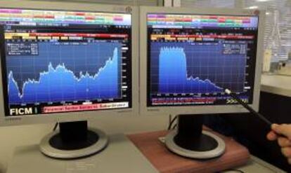 Pantalla que muestra la evolución del índice de referencia de la bolsa española, el IBEX 35 (i) y la prima de riesgo. EFE/Archivo
