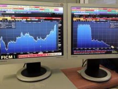 Pantalla que muestra la evolución del índice de referencia de la bolsa española, el IBEX 35 (i) y la prima de riesgo. EFE/Archivo