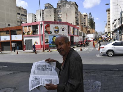 Un hombre lee un periódico, ayer en una calle de Caracas.