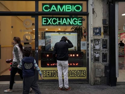 Transeunte olha tela com as cotações das moedas estrangeiras numa casa de câmbio no centro de Buenos Aires.