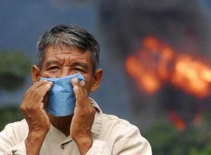 Un hombre se protege con una máscara del humo provocado por una de las explosiones en los gasoductos de Pemex, en Veracruz.