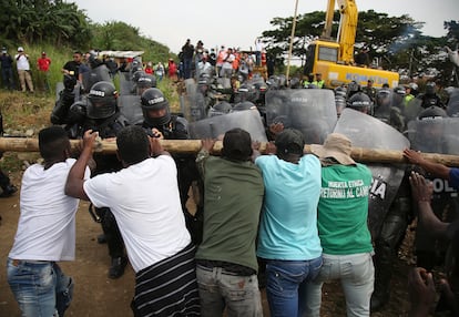 Los ocupantes ilegales se enfrentan con la policía antidisturbios para evitar el desalojo este jueves en Cali, Colombia.