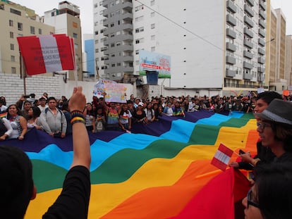 Un grupo de personas ondea una bandera arcoíris durante un desfile del Orgullo en Lima