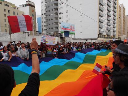 Un grupo de personas ondea una bandera arcoíris durante un desfile del Orgullo en Lima