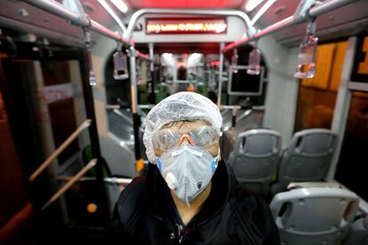 Un trabajador municipal limpia el interior de un autobús en Teherán (Irán), el 26 de febrero.