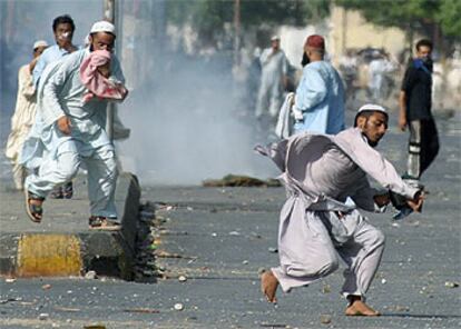 Seguidores del muftí Shamzai lanzan piedras contra la policía en Karachi.