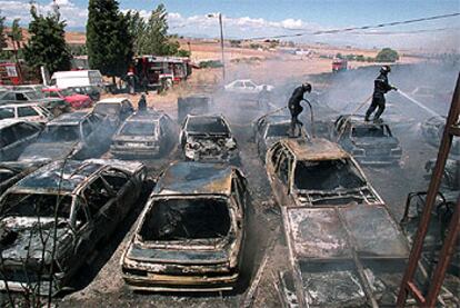 Los bomberos extinguen las llamas del desguace en el que quedaron calcinados 70 coches abandonados.