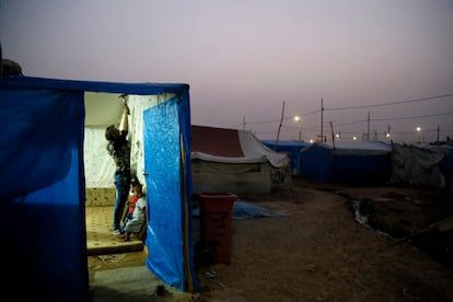 Una refugiada siria cuelga una cortina en su tienda de campaña en un asentamiento de tiendas de campaña en Irbil, al norte de Irak.