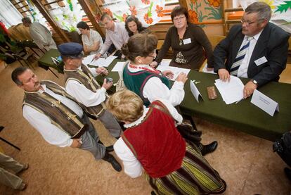 Un grupo de polacos vestidos con trajes tradicionales del país votan en un colegio electoral de Mackowa Ruda, al noreste de Polonia.