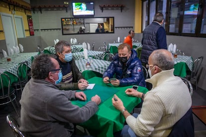 Unos hombres juegan una partida de tute en el interior de un bar tradicional de Madrid.