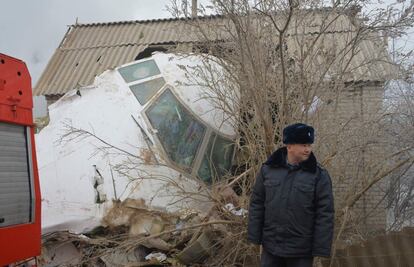 Un oficial de policía cerca de los restos del avión de carga turco accidentado en Bishkek.