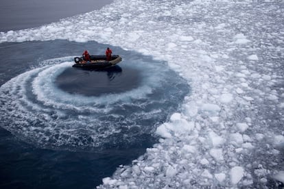 Oficiales de la marina chilena empujan el hielo moviendo su barco en círculos mientras se acerca el buque Aquiles.